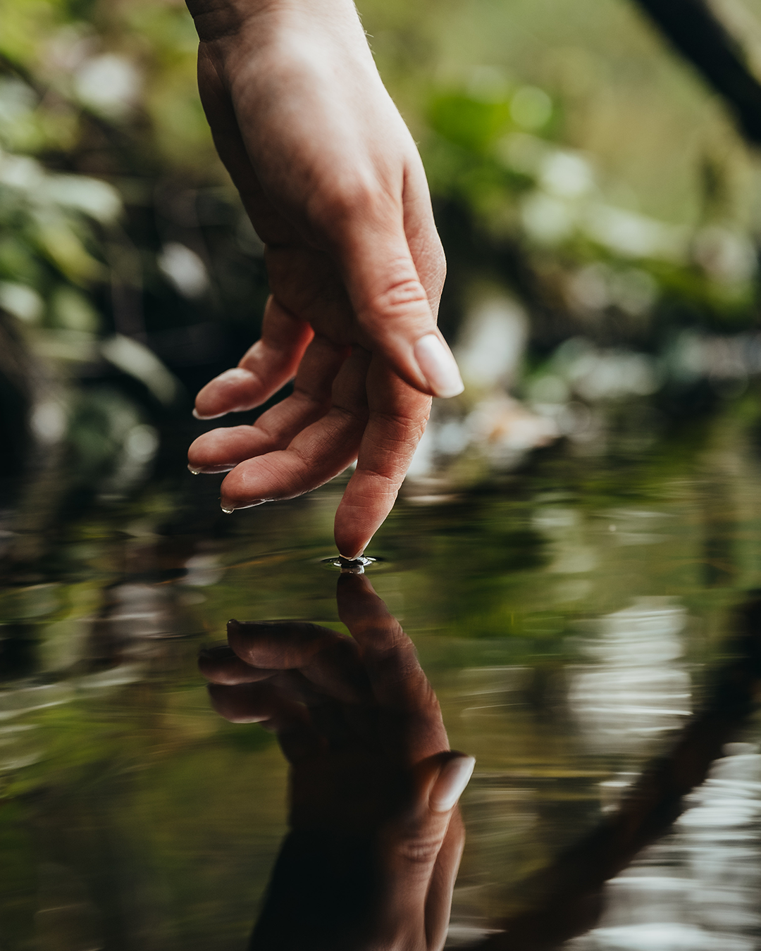 Hand touching water surface