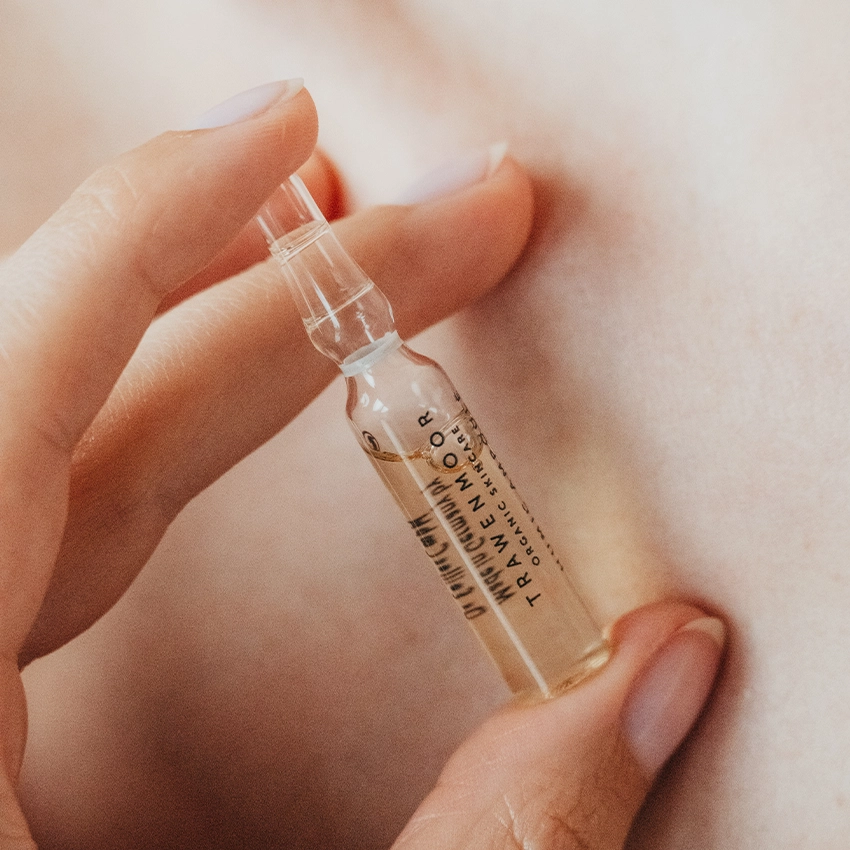 Frau hält Trawenmoor Ampulle mit zwei Fingern