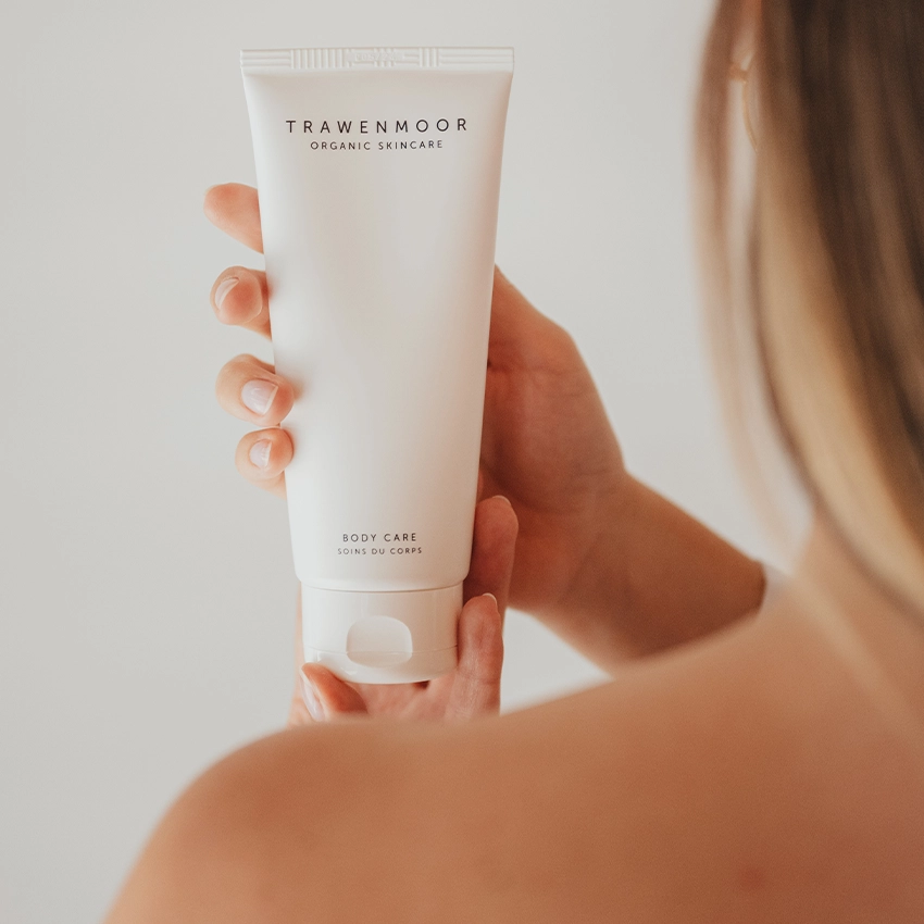 Frau hält Trawenmoor Hautpflege Tube in Hand über die Schulter